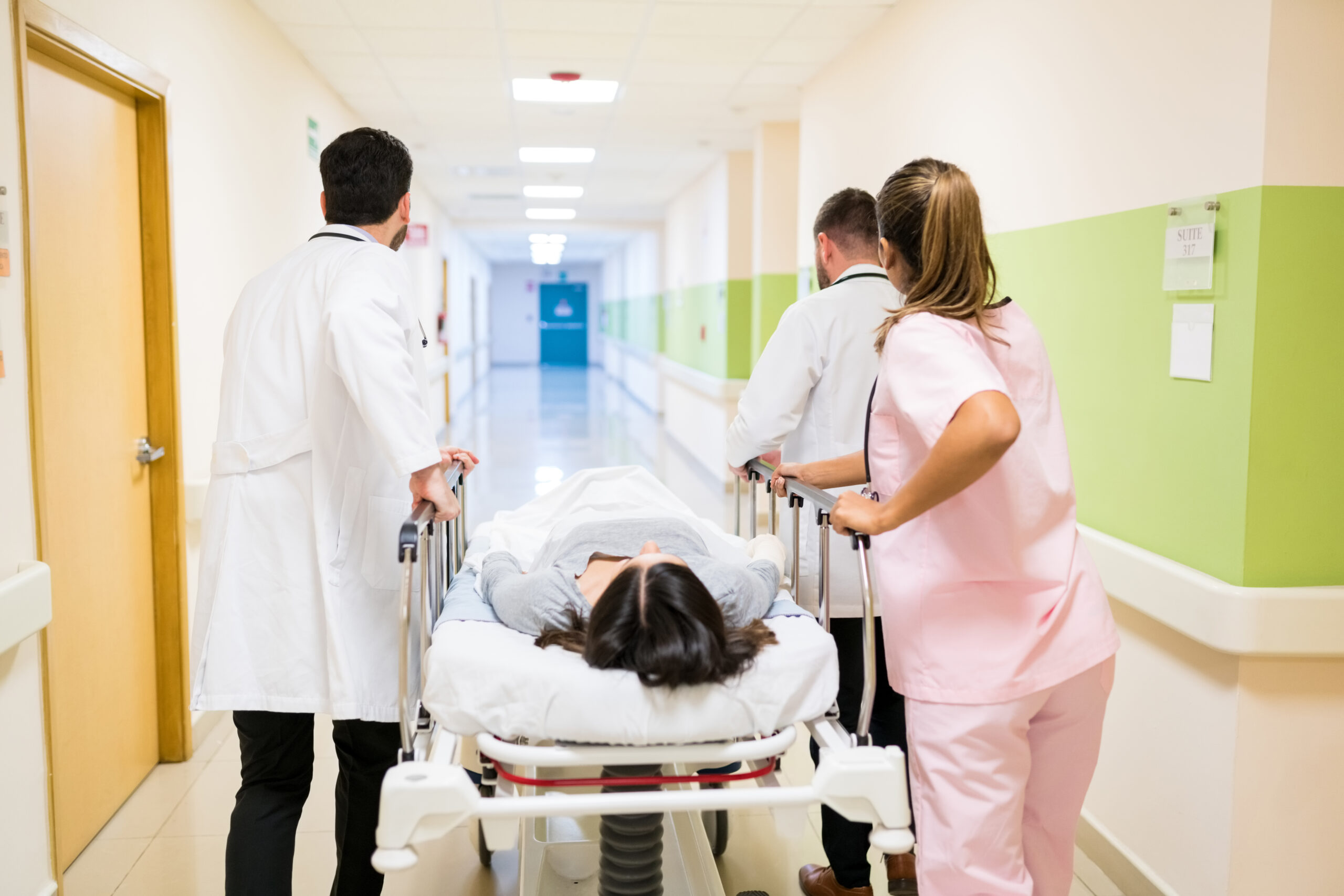 Medical Professionals Rushing Woman On Gurney In Hospital